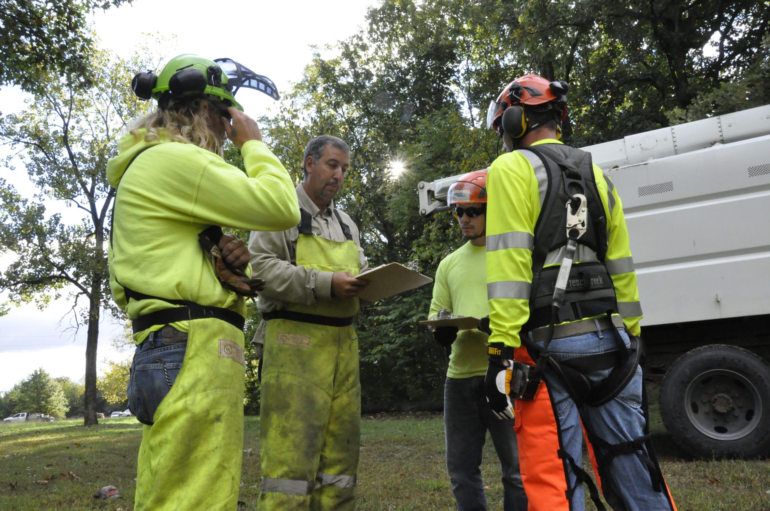 Male employees wearing protective clothing talking outside